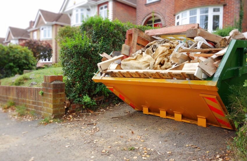 skip loaded with household waste on a driveway in Crawley